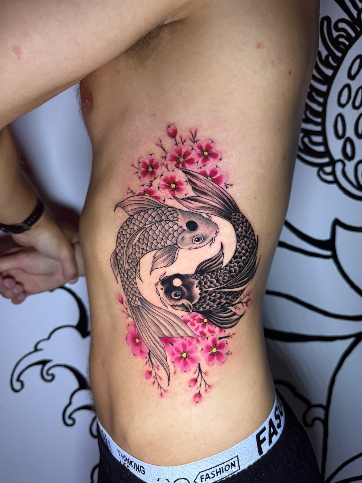 Colour tattoo of two koi fish with pink blossoms