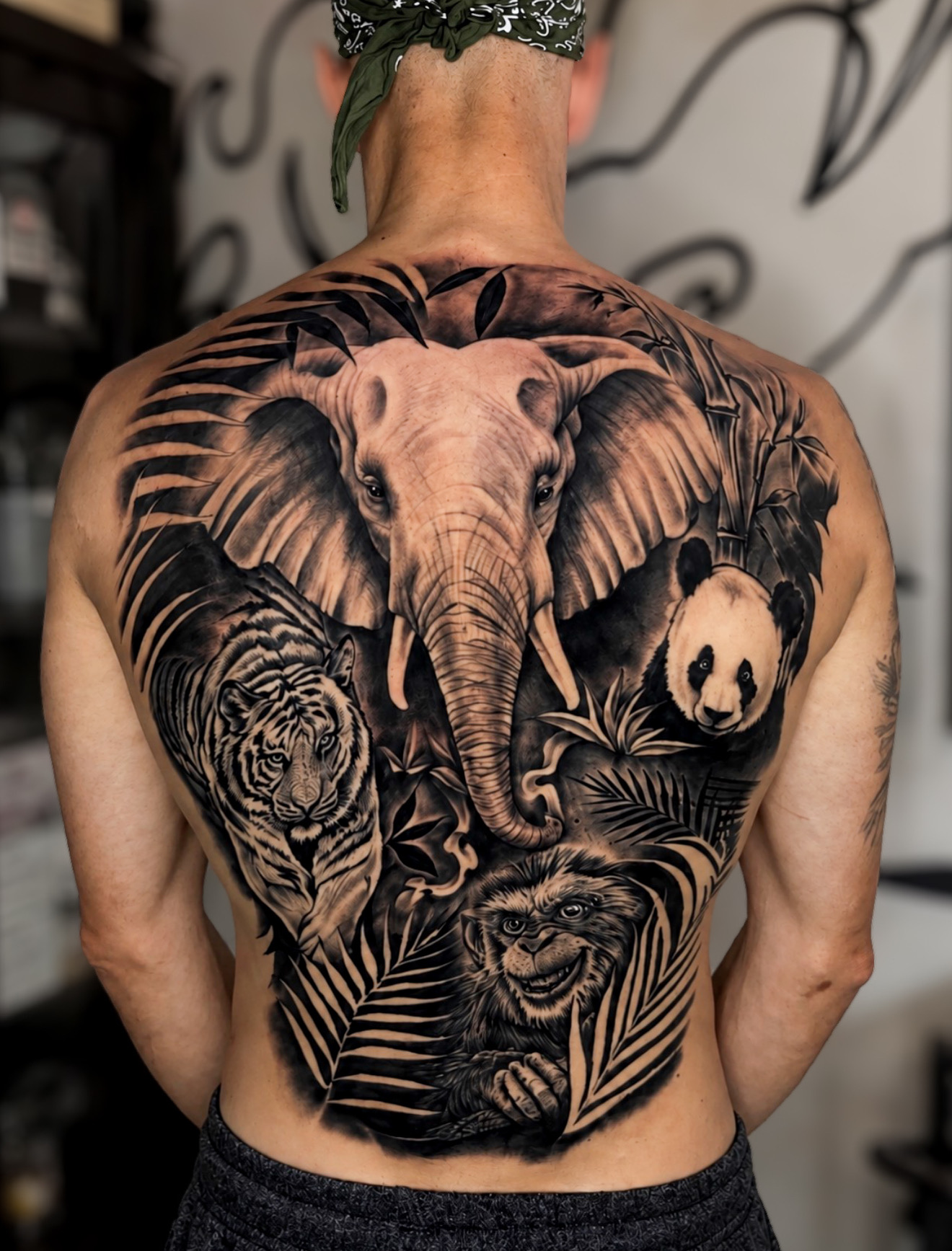Full back tattoo with elephant, panda, tiger and eagle
