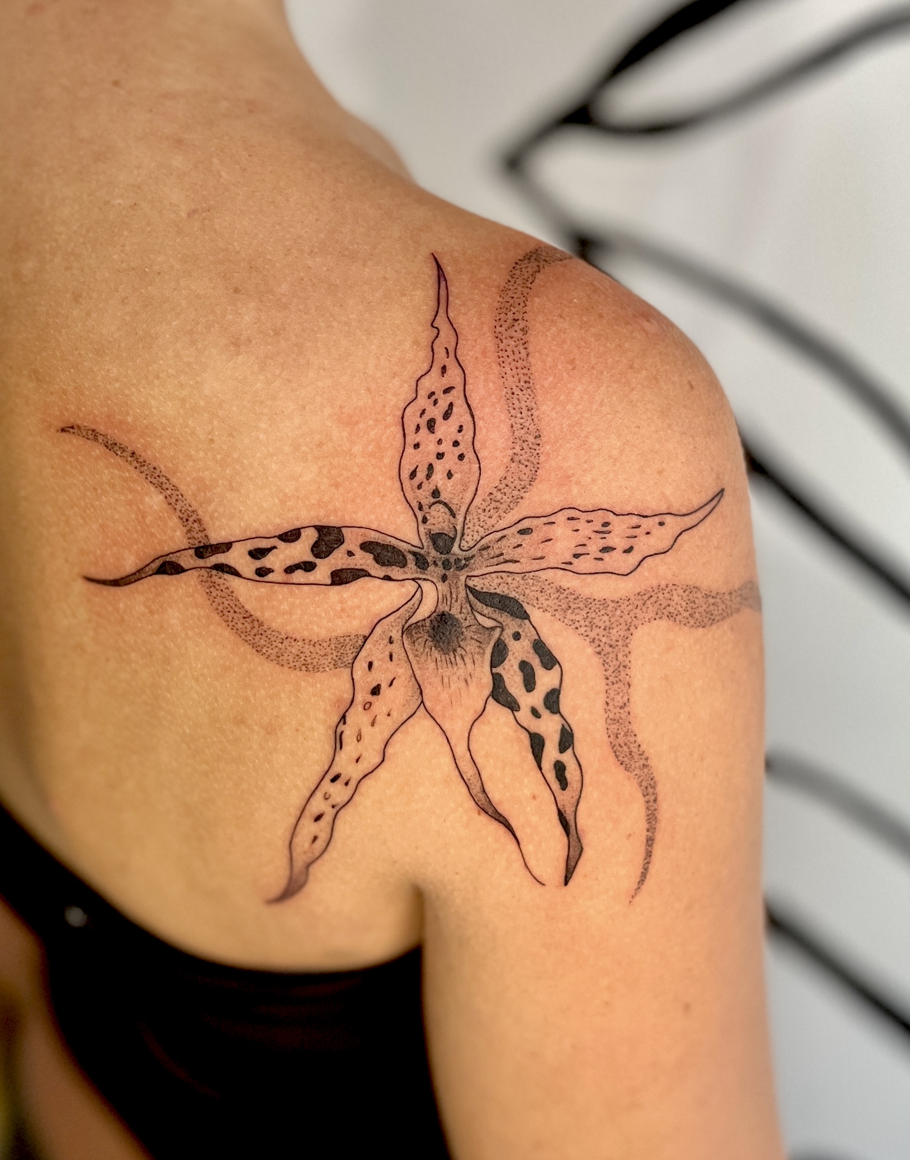 Spotted orchid tattoo on a shoulder